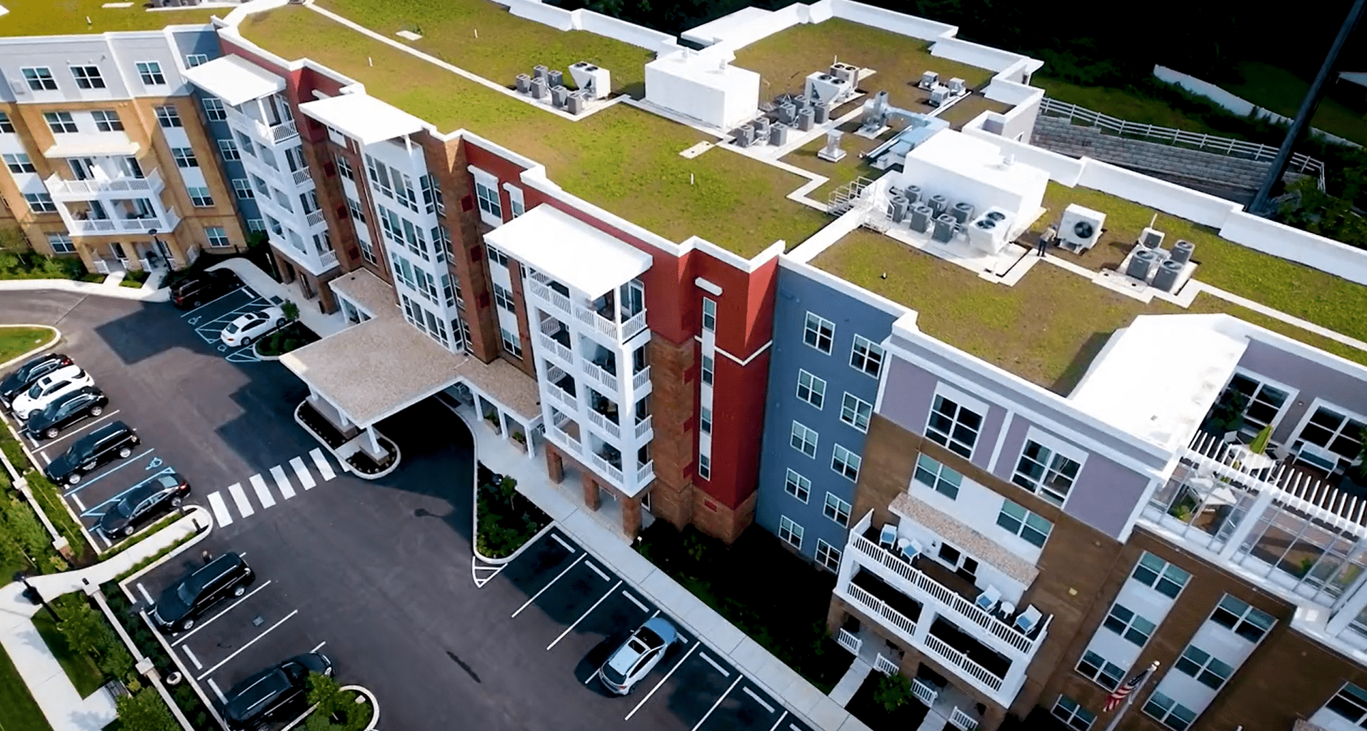 Green roof at Brightview Devon, grass like plants on a four story building with a person on the roof.