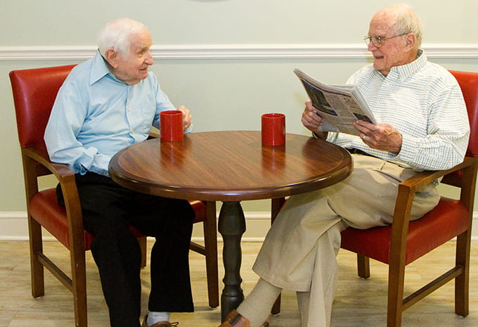 Brightview Wellspring Village Memory Care Residents reading newspaper and having coffee together