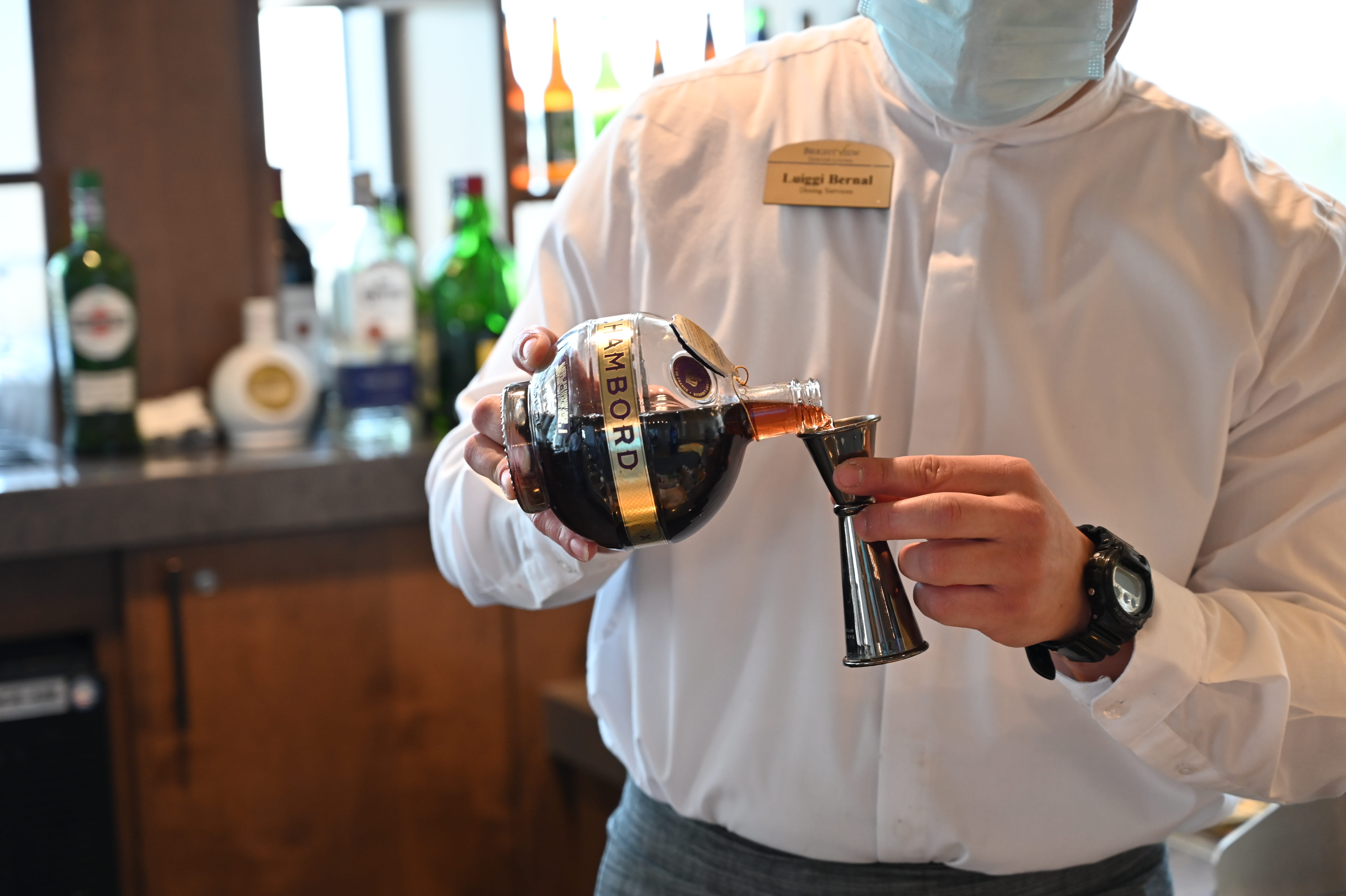 A man pouring liquor into a jigger