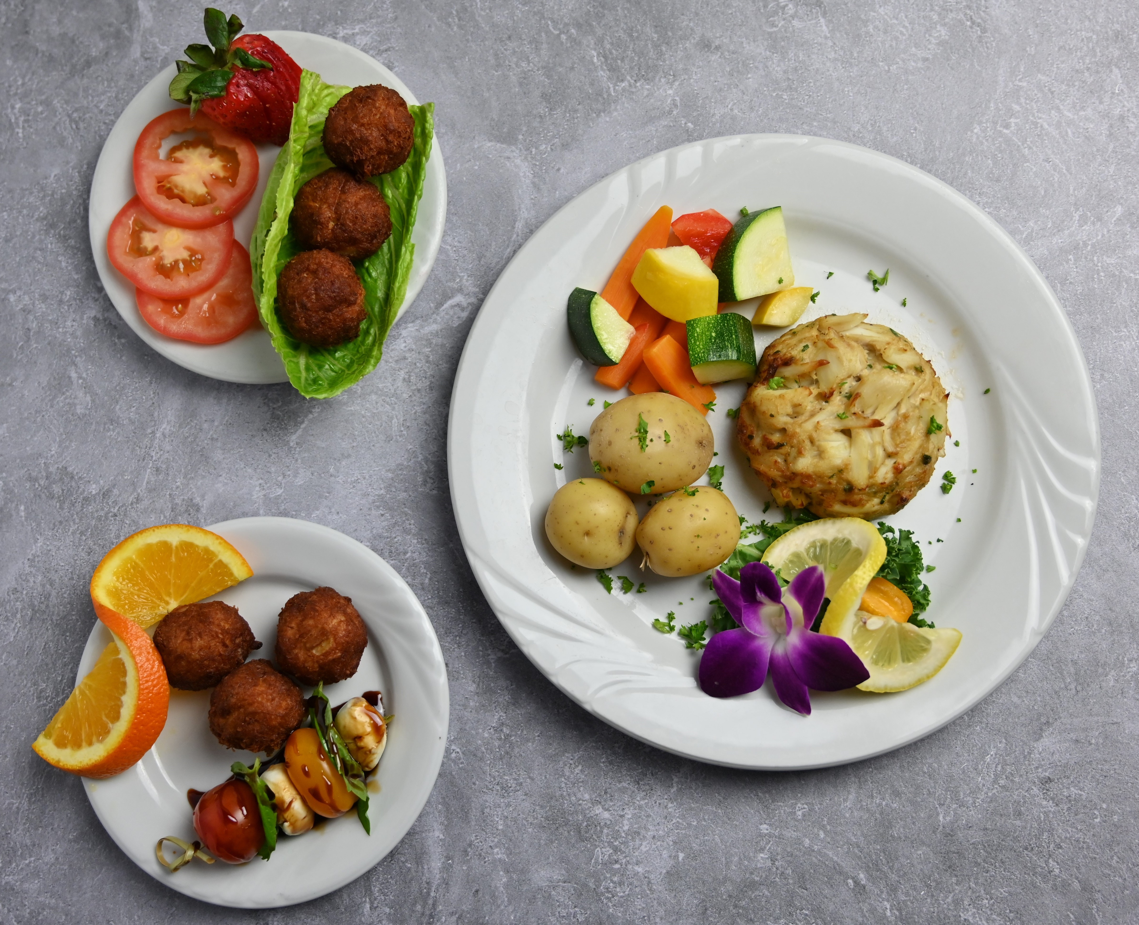 Crabcakes and crab balls on three plates