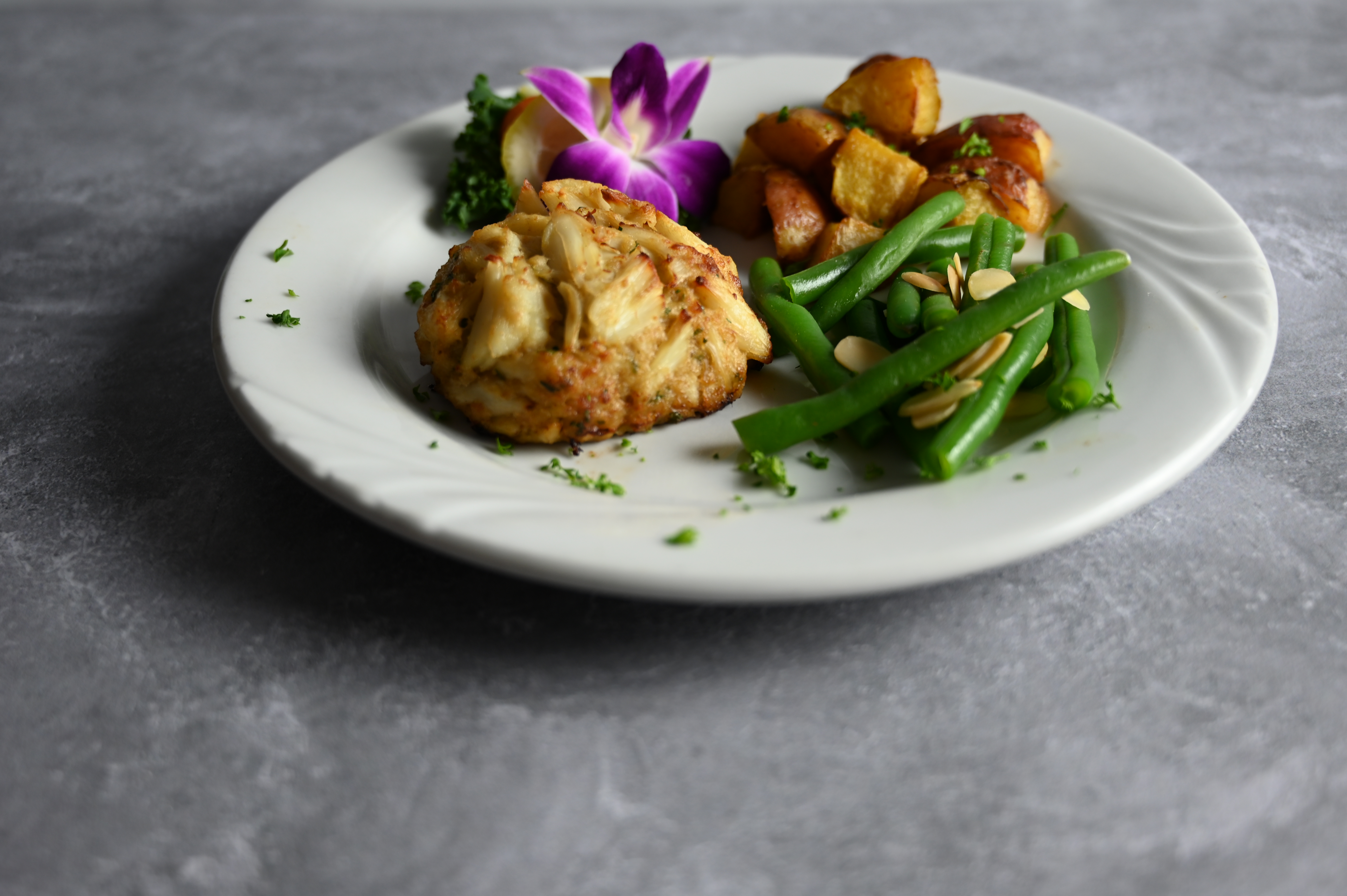 A crabcake on a plate with veggies