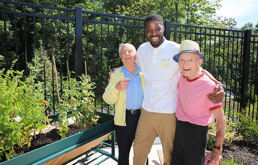 Wellspring Village Memory Care Residents enjoying outdoor patio and laughing with Brightview associate